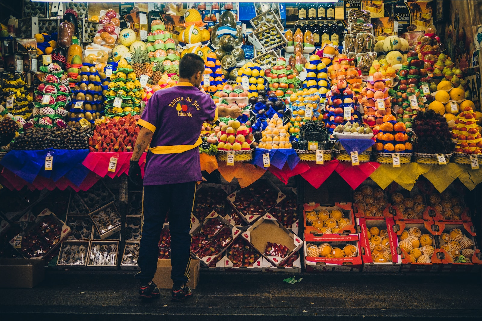 man standing in front of produce stand Тайские фрукты